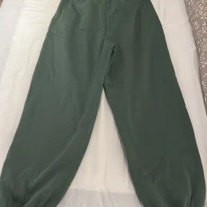 Gröna mjukisbyxor från BikBok - Säljer ett par gröna mjukisbyxor från BikBok i storlek M. Byxorna har en elastisk midja för extra komfort och en avslappnad passform. Perfekta för en chill dag hemma eller en avslappnad promenad.