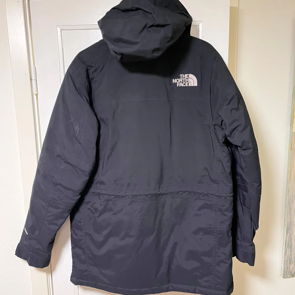 Säljer en svart jacka från The North Face med huva och flera praktiska fickor. Jackan har en dragkedja framtill och är perfekt för kyligare väder. Den är långärmad och har en stilren design med logotyp på bröstet och ryggen.. Takit.
