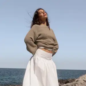 Säljer en mysig beige stickad tröja med rund hals och långa ärmar. Perfekt för kyliga dagar och enkel att matcha med olika outfits.