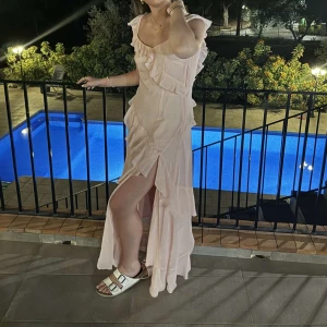 Rosa vollang klänning  - Säljer min rosa jätte fina volang klänning med en slits vid benet och djup i ryggen, pga att jag inte har någon användning för den. Klänningen har använts en gång på ett bröllop men jag hängt i garderoben sen dess. Köpt på nakd för runt 700 men slutsåld där!