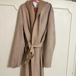 Beige trenchcoat med band - Elegant beige trenchcoat med knytband i midjan. Jackan passar perfekt för höst och vår. Den är köpt på Zara och är i väldigt bra skick. (Jackan är beige/ljusrosa) Pris kan diskuteras vid snabb affär. Skicka privat för mer bilder.