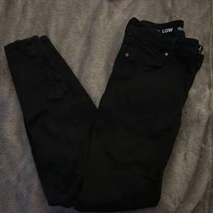 Svarta jeans med låg midja - Snygga svarta jeans med låg midja och smal passform. Perfekta för en stilren look.