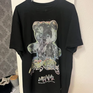 Svart t-shirt med nallemotiv - Cool svart t-shirt från Philipp Plein med ett stort,  nallemotiv på framsidan. (Äkta) Perfekt för dig som vill sticka ut med en unik design.