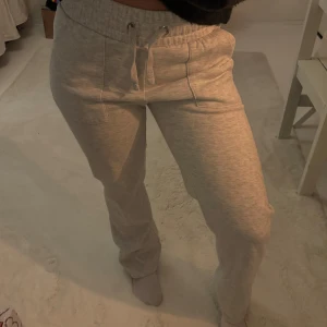 Grå mjukisbyxor med snörning - Säljer ett par bekväma grå mjukisbyxor med snörning i midjan. Perfekta för en avslappnad dag hemma eller en snabb tur till affären. Byxorna har en loose passform och är tillverkade i mjukt material.