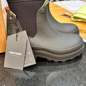 Svarta boots från Tretorn - Snygga och robusta svarta boots från Tretorn. De har en hög sula och är perfekta för regniga dagar. Designen är stilren med elastiska paneler för enkel på- och avtagning.