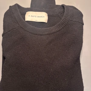Svart polotröja från A Day's March - Snygg och stilren svart stickad tröja från A Day's March. Perfekt för kyligare dagar med sin mjuka och bekväma passform.