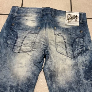 Blå jeans från Blue Berry storlek 26 - Snygga blå jeans från Blue Berry med en unik tvättad look. De har fem fickor och en klassisk knappgylf. Perfekta för en avslappnad stil.