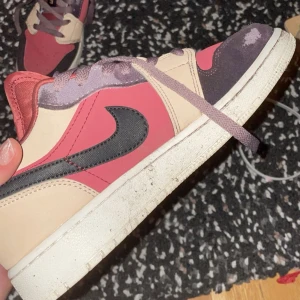 Nike Air Jordans i rosa och beige - Säljer ett par Nike Air Jordans i en snygg kombination av rosa och beige med svarta detaljer. Skorna har en klassisk snörning och en bekväm sula. Perfekta för dig som vill ha en stilren och sportig look.