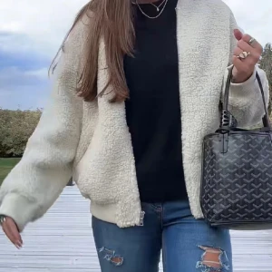 Beige teddyjacka från Lindex  - Mysig beige teddyjacka från Lindex  med dragkedja och ribbade muddar. Perfekt för kyliga dagar med sin fluffiga och varma design. Jackan har en avslappnad passform och två praktiska fickor framtill.