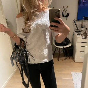 Vit offshoulder topp - Säljer en stilren vit offshoulder topp med en avslappnad passform. Perfekt för en trendig look, kan stylas både upp och ner. Toppen har en mjuk och bekväm känsla. Har klippt den lite mer off shoulder själv, men tröjan hade redan sen innan en avklippt känsla vid köp. Mycket bra skick annars. I storlek S