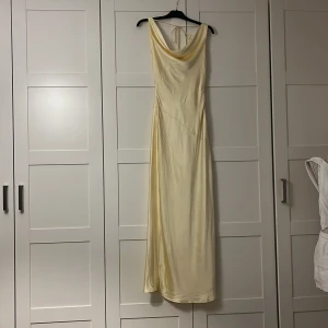 Gul balklänning - Så vacker balklänning som ännu inte fått någon användning pågrund av att jag valde en annan klänning🫶🏼 öppen i ryggen och en drapering på framsidan. I en så fin gul färg i satin och är helt i nyskick 