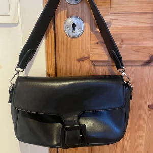 Handväska - Snygg svart axelväska från Bik Bok, väskan har en innerficka med dragkedja och har inte blivit använd💓