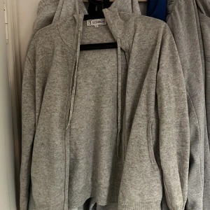 Grå hoodie från Studios - Säljer en stilren grå hoodie från Studios i storlek S. Den har en dragkedja framtill och en bekväm huva. Perfekt för en avslappnad look. 100% Kashmir. Sjukt laidback och alla guzzar kommer springa efter dig 
