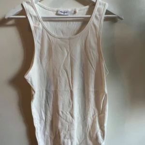 Vit ribbat linne (Vailent) - Säljer ett stilrent vit ribbat linne från Vailent. Perfekt för varma sommardagar med sin enkla och klassiska design. Toppen har en rund halsringning och är ärmlös. Använd 1 gång.  Originalpris: 199kr (Katt finns i hushållet. Rengörs före frakt.)