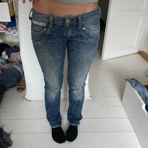 Blå jeans från Herrlicher - Säljer ett par snygga blå jeans från Herrlicher. De har en låg midja och en bootcutpassform. Jeansen har klassisk femficksdesign och en lätt tvättad look för en avslappnad stil.