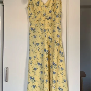 Blommig klänning Elsa Hosk/Bik Bok - Klänning från Bik Bok, kollektion av Elsa Hosk.  Storlek M.  Dragkedja i midjan och knytbara band vid axlarna.   Har en fläck på framsidan, se bild.