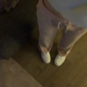 Rosa juicy byxor - Ett par rosa juicy byxor endast lite smuts som inte går bort längst ner eftersom jag råkat trampa på dom men dom är inte sönder vars lite mörkare i färgen där nere då! Byxorna är i xs ganska använda men inte slitna så!