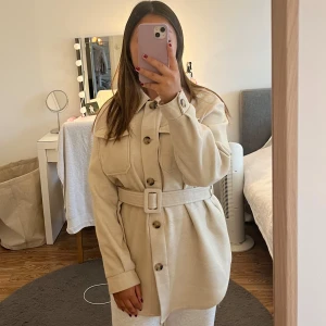 Beige kappa - Beige kappa från Vero Moda. Använd men i bra skick. Strl: S.