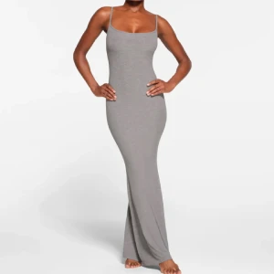 Grå långklänning med smala axelband från skims  - Elegant grå långklänning med smala axelband och figurnära passform. Klänningen har en stilren design som framhäver silhuetten och är perfekt för en chic look.