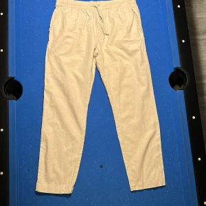 Beige linnebyxor  - Säljer ett par beige linnebyxor. Perfekta för varma dagar med sitt lätta och luftiga material. Storlek L