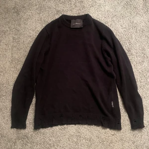 Svart stickad tröja från John Richmond - Säljer en stilren svart stickad tröja från John Richmond. Nästan oanvänd. Tröjan har långa ärmar och ribbade detaljer vid ärmslut och nederkant. Perfekt för en avslappnad look. Hör av dig vid intresse! Storlek S men sitter som XS