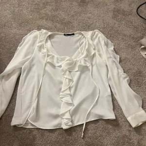 Volang blus Zara - Säljer denna jättefina volang blusen från Zara. Använd 1 gång, säljer pågrund av att den inte kommer till användning.