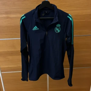 Real Madrid träning tröja  - Tja!!  Nu säljer jag denna mörkblå långärmad träningströjan från Adidas med ljusblå detaljer och dragkedja. Gillar du real Madrid eller fotboll så är denna perfekt! Den är helt nyskick 10/10 skulle vilja säga att den passar S hur var som helst så den är en xs-S 