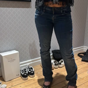 Blå jeans med bootcut - Snygga blå jeans med bootcut-stil och klassisk femficksdesign. Jeansen har en normal passform och är perfekta för en avslappnad look. De har en traditionell dragkedja och knapp framtill.