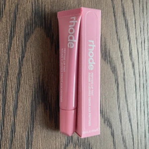 Rhode Peptide Lip Tint - Rhode Peptide Lip Tint i färgen ”ribbon”. Denna läpprodukt ger en subtil färg och återfuktar läpparna med peptider. Perfekt för en naturlig look.