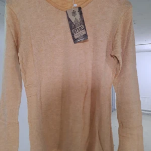 Beige långärmad tröja från C&A - Säljer en stilren beige långärmad tröja från C&A. Perfekt för en avslappnad look. Tröjan har en enkel design och är gjord i ett mjukt material som känns skönt mot huden.