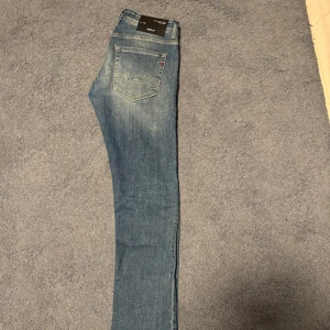 Blå jeans från Replay - Snygga blå jeans från Replay med en klassisk straight passform. De har en lätt tvättad look och är perfekta för en avslappnad stil. Jeansen har dragkedja och knapp framtill samt fem fickor.