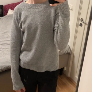 Grå stickad tröja från Vero Moda - Säljer en stickad grå tröja från Vero Moda. Tröjan har en klassisk rund halsringning och långa ärmar. Perfekt för en avslappnad look. 