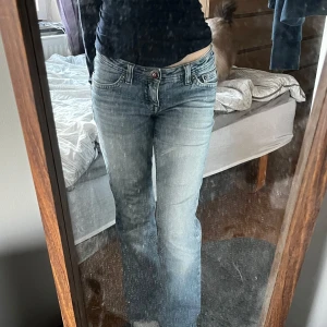 Blå jeans bootcut - Snygga blå low waist jeans med en klassisk bootcut-stil och tvätt fram samt över rumpan. De har en bekväm passform och är i bra skick. Passar bra till 160cm ish! Jag är 157.