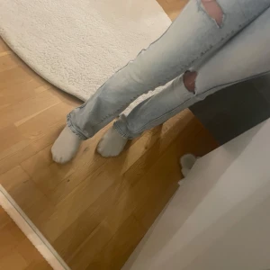 Ljusa low waist bootcut jeans med slitningar - Snygga ljusa jeans med slitningar på knäna. Jeansen ser lite konstiga ut på mig pga dom är för små för mig!! Dessa sälj inte längre i butik och är min mammas💝😘😊🫰🏼strlk: 158/xxs/xs