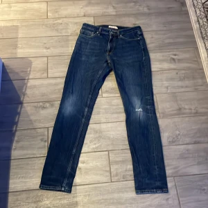 Blå jeansbyxor - Snygga blå jeansbyxor med en klassisk straight passform. De har en dragkedja och knapp framtill samt fem fickor. Perfekta för en avslappnad stil.