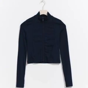 Mörkblå jacka med dragkedja - Snygg mörkblå jacka med dragkedja framtill. Jackan har en tight passform och långa ärmar, perfekt för en stilren look. Materialet är mjukt och stretchigt, vilket gör den bekväm att bära. köpt för 279kr