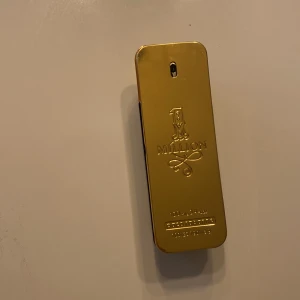 1 Million Eau de Toilette från Paco Rabanne - Säljer en flaska 1 Million Eau de Toilette från Paco Rabanne. Den är nästan helt full använd några gånger bara. Flaskan är i guld och rymmer 100 ml. Den har en lyxig design som påminner om en guldtacka. Perfekt för den som vill ha en doft med stil och elegans.