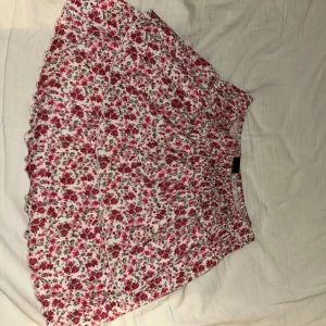 Blommig kjol från Gina Tricot - Super söt blommig kjol från Gina Tricot med volangdetalj, väldigt lätt och bekväm för sommaren, inte använd, ordinarie pris 200