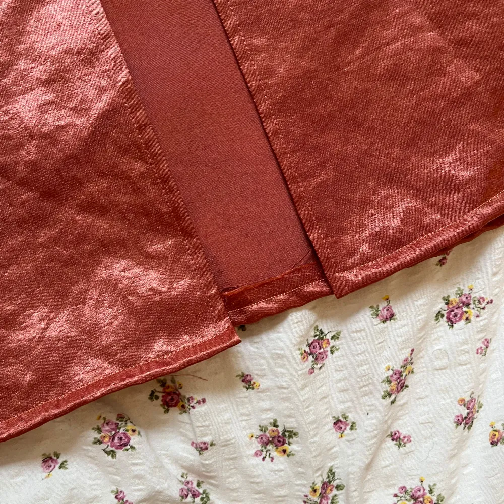 Elegant rosa långklänning med smala axelband och en subtil slits framtill. Klänningen har en v-ringad design och är tillverkad i ett glansigt material som ger en lyxig känsla. Perfekt för speciella tillfällen. Uppsydd längst ner men lång nog för att ha klackar i om man är 174 som jag.. Mekot.