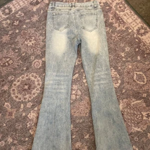 Ljusblå bootcut jeans - Snygga ljusblå bootcut jeans med en klassisk femficksdesign. De har en lätt tvättad look som ger en avslappnad stil. Perfekta för en trendig vardagslook.