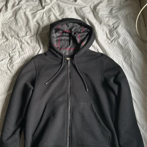 Svart Burberry zip hoodie - Snygg svart hoodie från Burberry. Använd 1-3 gånger, men ser helt ny ut. Storlek L 