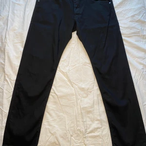 Svarta jeans från Diesel - Snygga svarta jeans från Diesel med klassisk design. De har en normal passform och är tillverkade i slitstarkt denim. Perfekta för en stilren look.