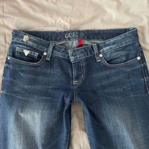 Lågmidjade Guess Jeans  - Superlåga jeans från Guess! Ursprungligen i strl 30 men omsydda till 28/29, inget som går att sprätta upp! Ena märket saknas på bakfickan men skickar med det så man kan sy / limma på det själv! Midjemått: 40 Innerben: 82 