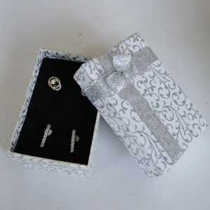 Set med örhängen i silver - Elegant set med två par örhängen. Ett par i silver med gnistrande stenar och ett till par i silver med stenar i nederkant, som man kan de så är det översta paret mer använda än de andra men inget man tänker på när de används. Därav kan priset diskuteras! Perfekt för att ge en touch av glamour till din look. Levereras i en vacker presentask med silvermönster och rosett.