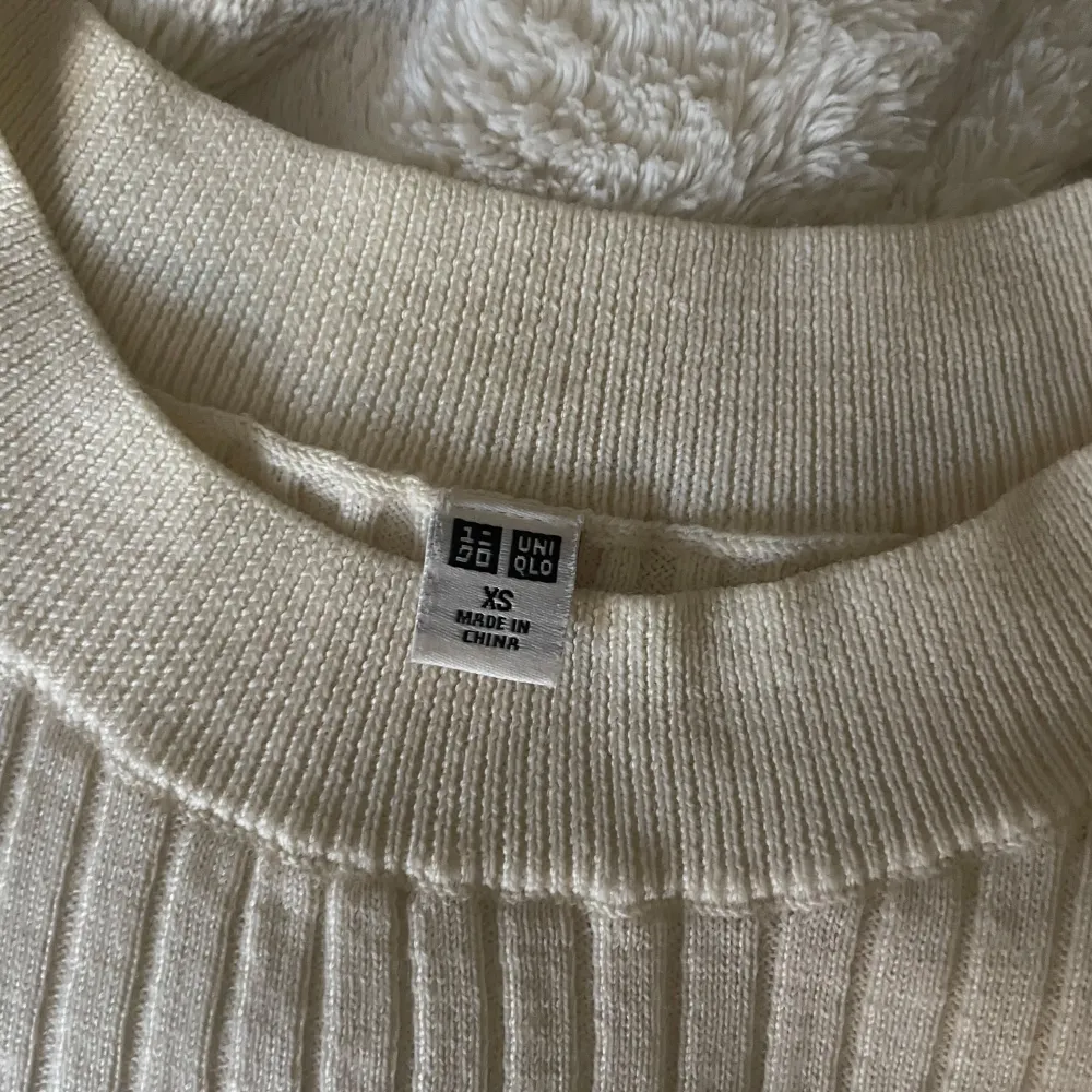 Säljer en stilren vit ribbad tröja från Uniqlo. Tröjan har en klassisk rund hals och trekvartsärmar! 100% ull💕. Puserot.