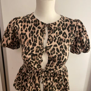 Leopardmönstrad blus från Gina Tricot - Gullig leopard printad blus från ginatricot, perfekt skick och har bara blivit använd 2 gånger förut. Den har lite öppning med rosetter och sen en volang längst ner.