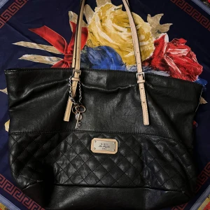 En svart axelväska från Guess - Har små tecken på användning på utsidan, ren och hel inuti. 