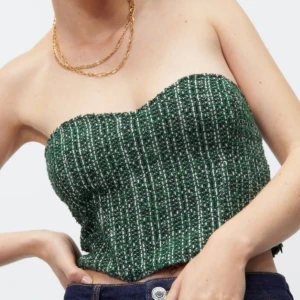 Grön korsett topp - Snygg grön korsett topp från Zara med ett jättefint rutmönster. Toppen är axelbandslös och har en croppad passform. Endast använd en gång, storlek XS