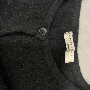 Svart kofta från Gina Tricot - Säljer en stilren svart kofta från Gina Tricot i premiumkvalitet. Koftan har knappar framtill och är perfekt för kyligare dagar. Ett mångsidigt plagg som passar till det mesta i garderoben. Hör av dig om funderingar🩷