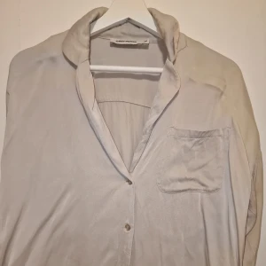 Beige skjorta från Carin Wester  - Säljer en stilren beige skjorta från Carin Wester. Skjortan har en klassisk krage och knappar framtill. Perfekt för en minimalistisk look. Garderobsrensning så kika gärna på övriga auktioner.